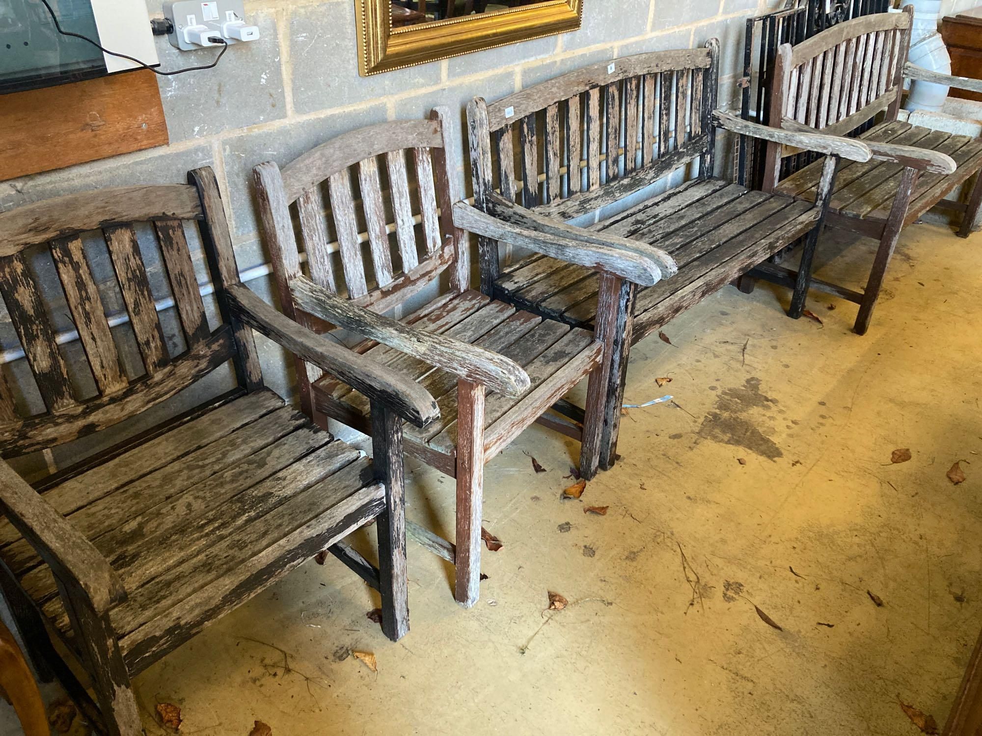 Two stained teak garden benches and matching armchairs, bench widths 126cm and 123cm